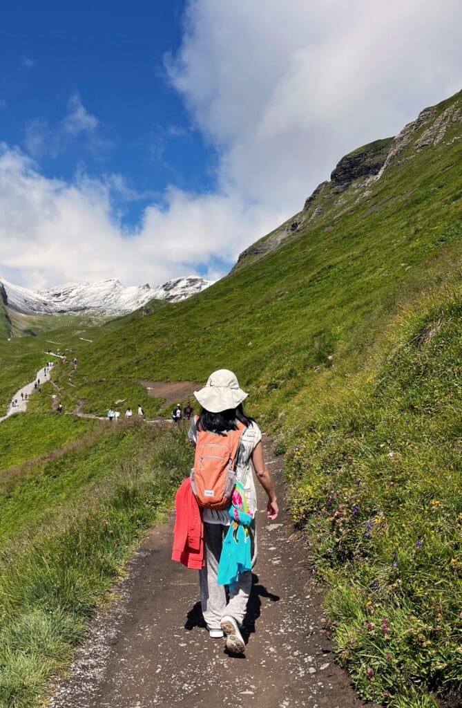 Woman hiking toward Bachalpsee Lake in Grindelwald, symbolizing the journey toward healing and resilience